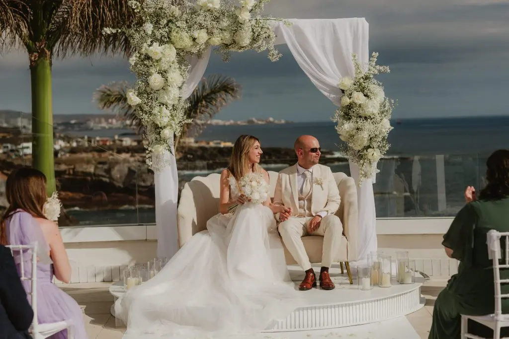 Ceremonia de boda con arco floral y el mar al fondo, diseño de Kandas