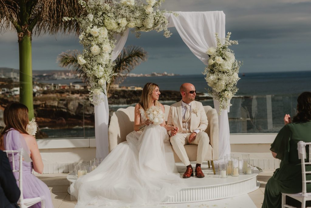 Ceremonia de boda con arco floral y el mar al fondo, diseño de Kandas